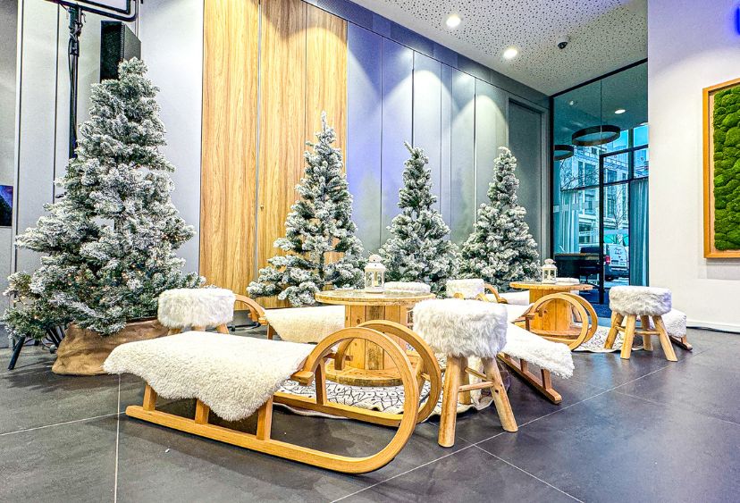 Winter-Wonderland-Deko mit weißen Loungemöbeln, Tannenbäumen und Lichterglanz auf einer Weihnachtsfeier in Frankfurt