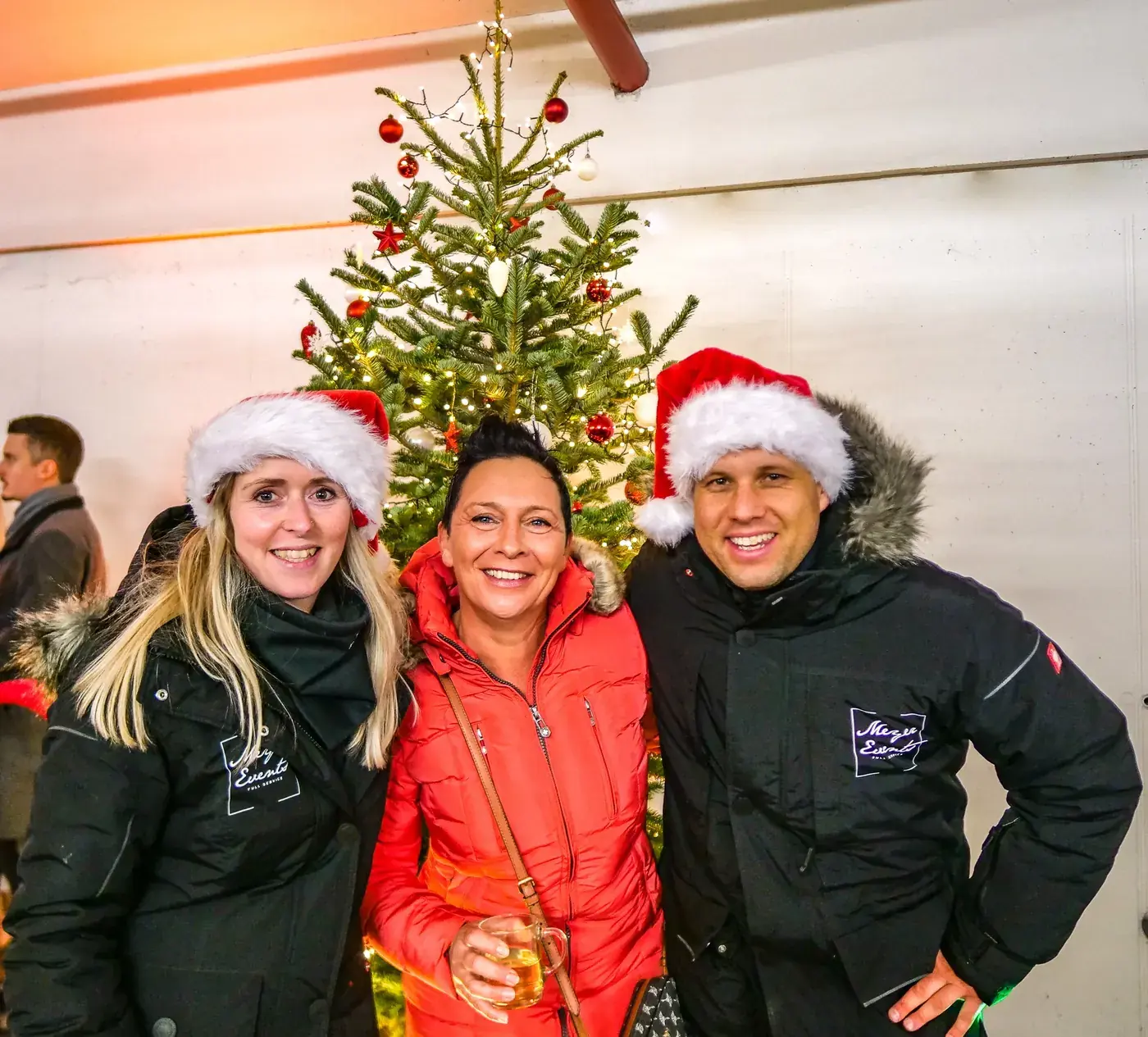 Patricia und Martin Meyer mit Kundin auf einem Weihnachtsmarkt