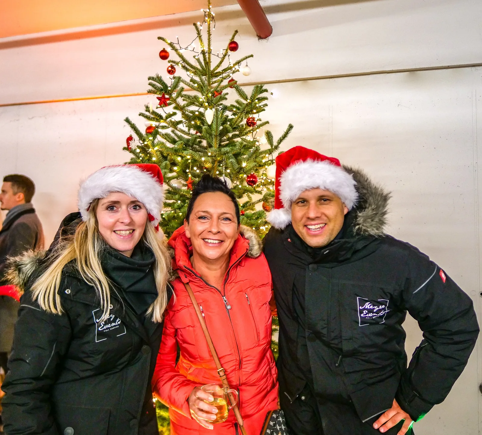 Patricia und Martin Meyer gemeinsam mit einer Kundin auf einem Firmenweihnachtsmarkt