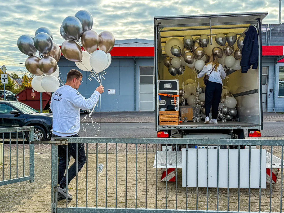 Martin und Patricia bereiten den Transport goldener und silberner Ballons vor