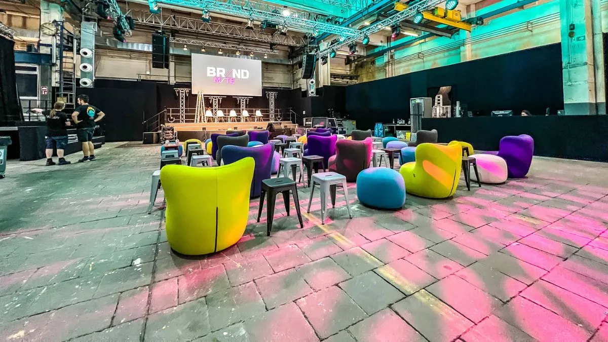 Eventdekoration zum Mieten: farbige Loungemöbel und dekorative Lichtgestaltung in einer Industriehalle
